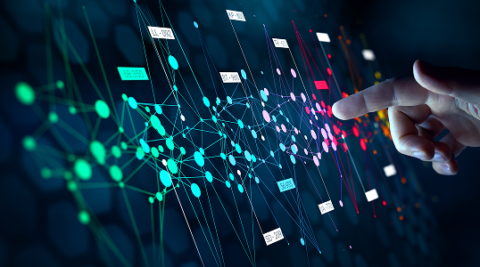 A hand pointing at data analytics on a screen.