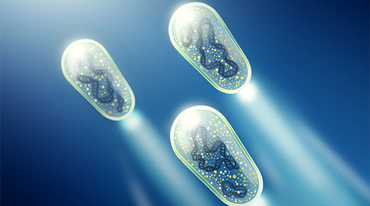 An illustration of three glowing, capsule-shaped microscopic devices floating in a dark blue environment. Each capsule contains intricate internal structures and emits bright beams of light, giving the impression of motion through a fluid-like space.