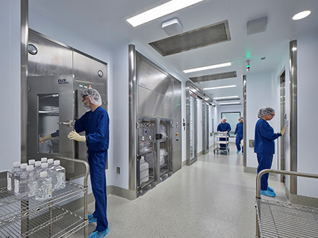 Personnel in clean hallway getting ready for manufacturing within the Clinical Vector Core.