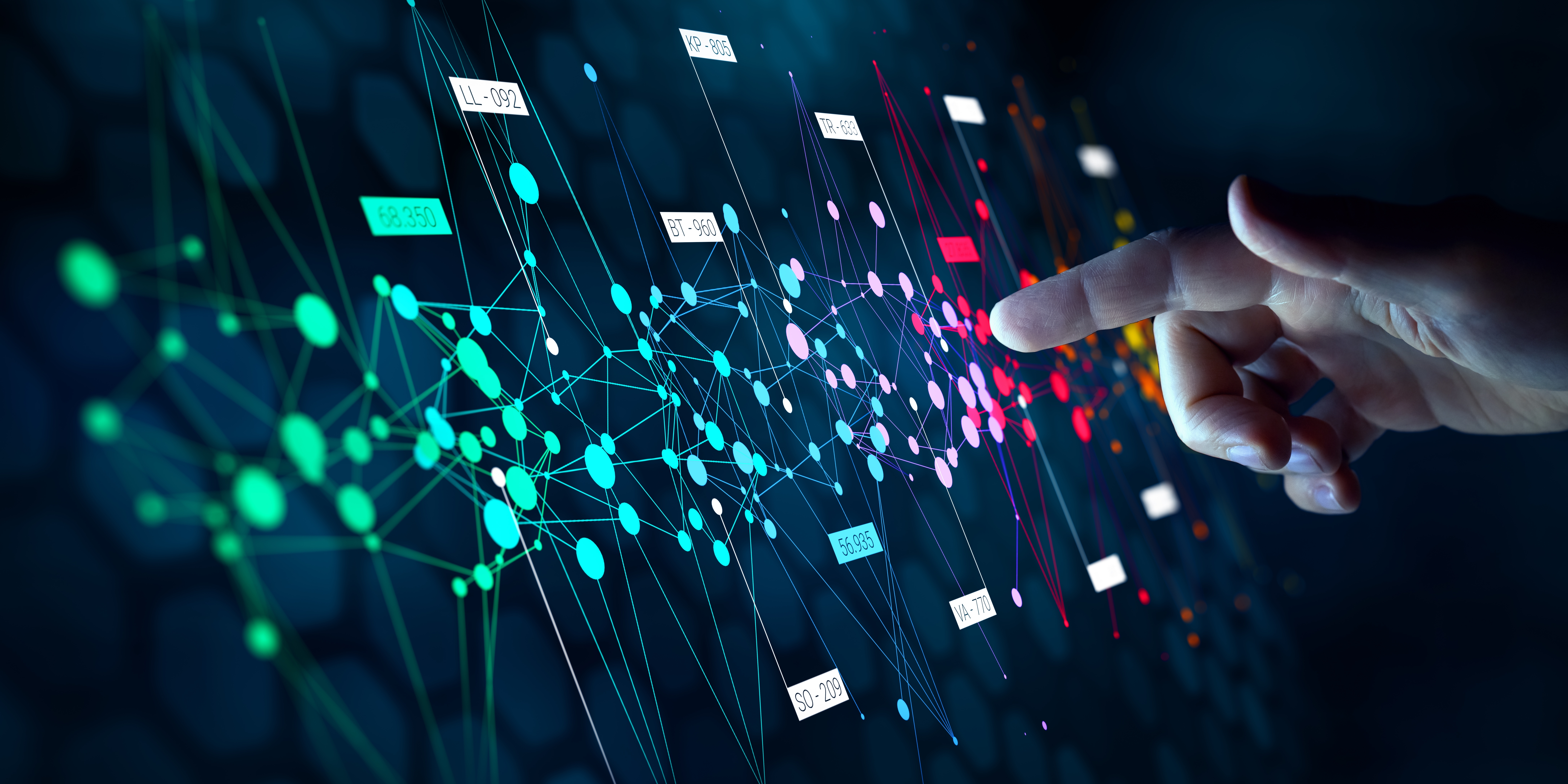 A hand pointing at data analytics on a screen.