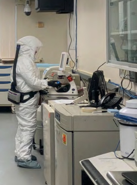 Scientists in personal protective equipment in a lab.