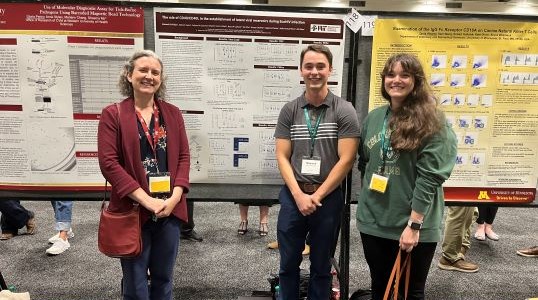 Dr. Metcalf Pate standing with Mr. Maxwell Phillips and Dr. Guerrero-Martin in front of a research poster.