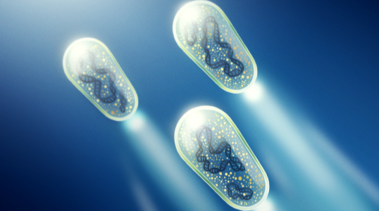 An illustration of three glowing, capsule-shaped microscopic devices floating in a dark blue environment. Each capsule contains intricate internal structures and emits bright beams of light, giving the impression of motion through a fluid-like space.