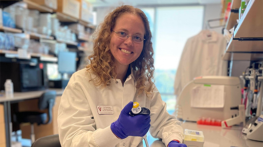 A scientist holding a pipette in a laboratory.