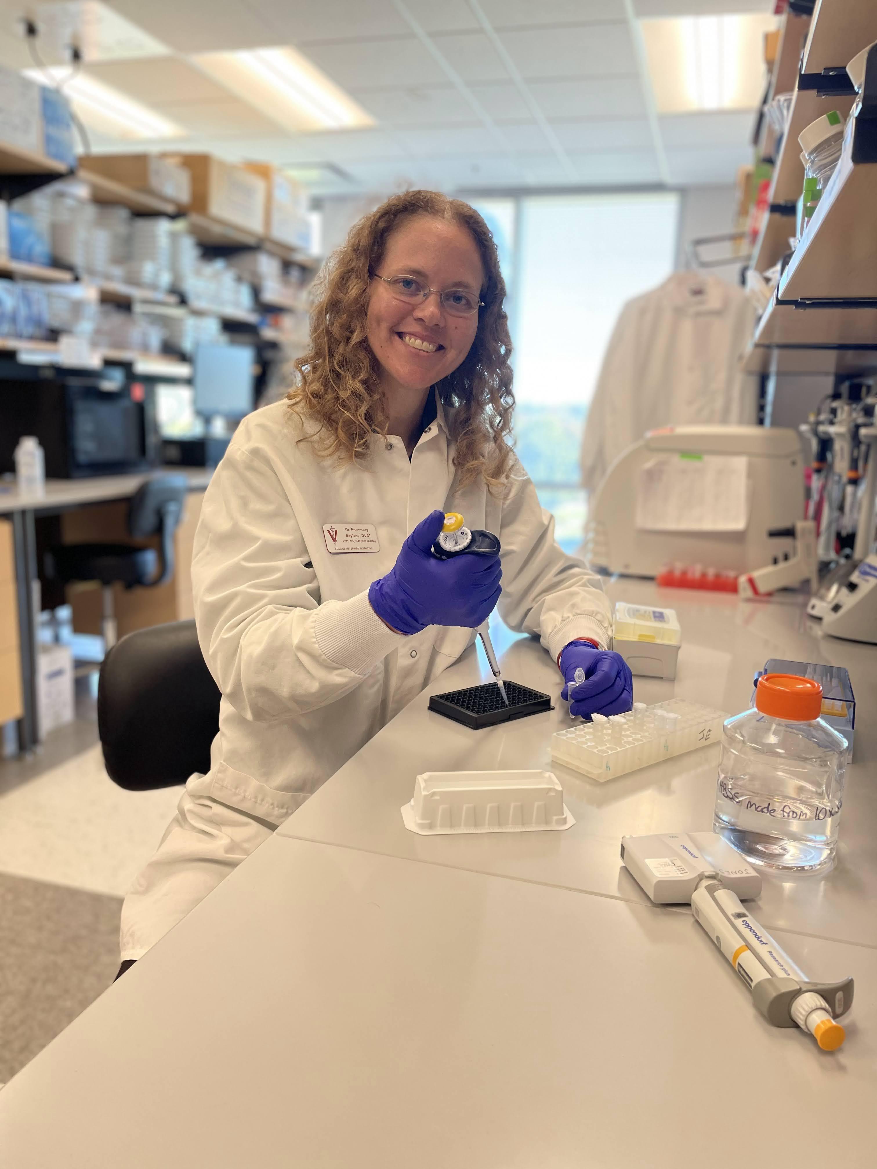 A scientist holding a pipette in a laboratory.