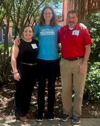 Three people standing together.